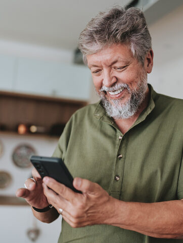 Portrait Of A Senior Man Using Smartphone At Home